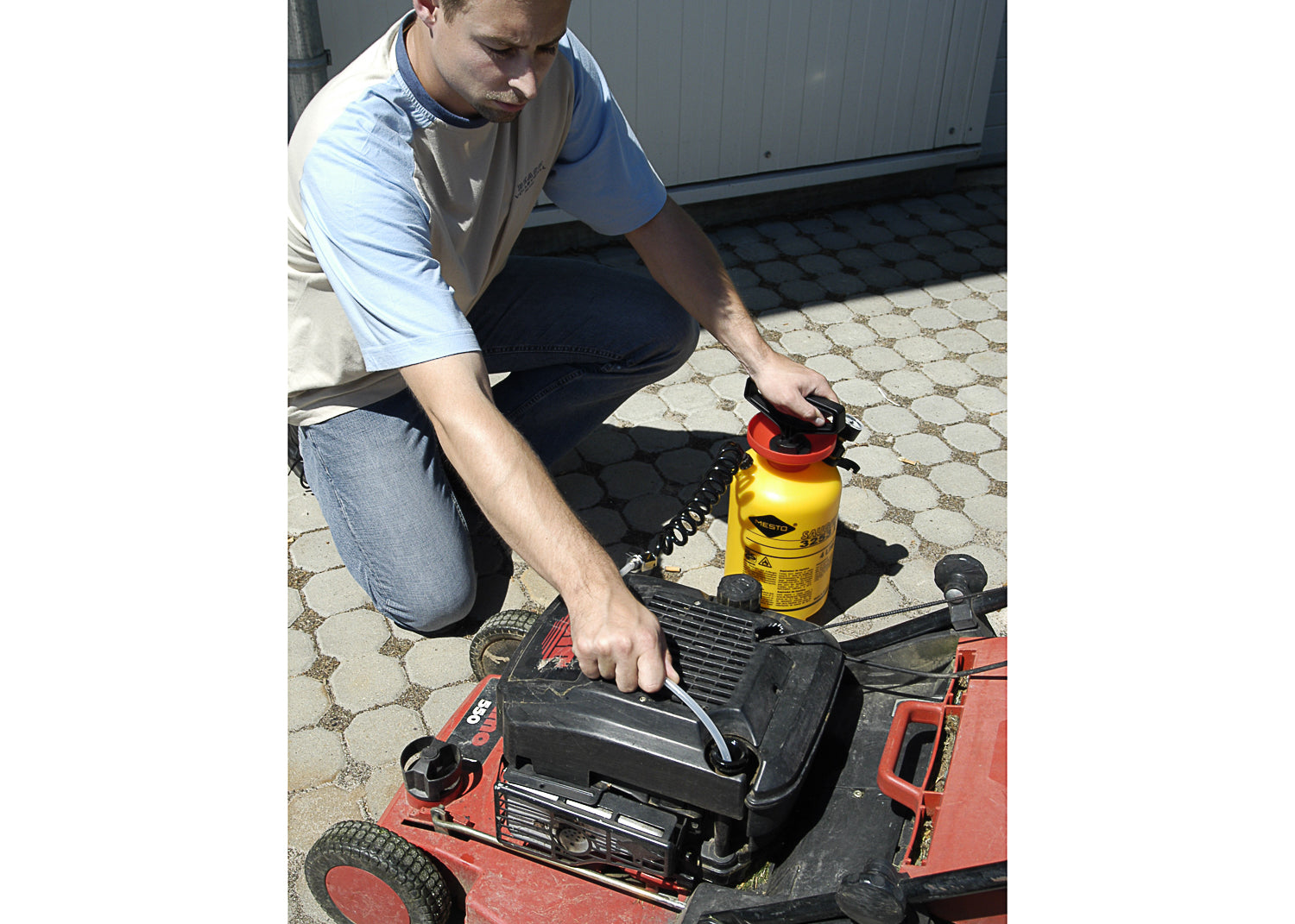 photo showing our liquid suction tank being used to remove 2petrol from the tank of a lawn mower