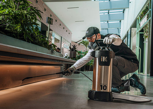 metal sprayer being used to spray cleaning solution within an airport